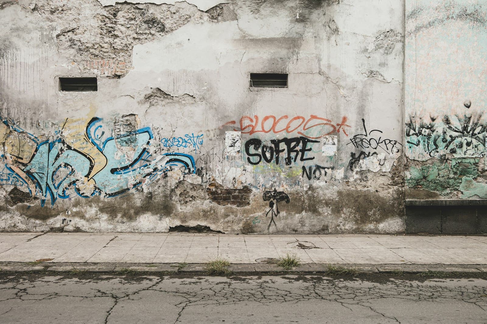 Graffiti tags on a weathered exterior wall