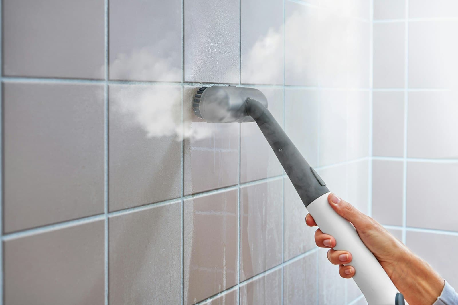 Steam cleaner being used on a tiled wall
